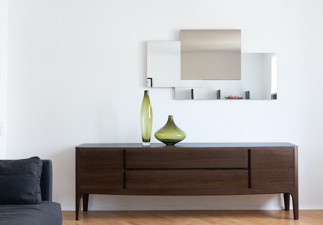 minimalistic furniture and a mirror hanging above it