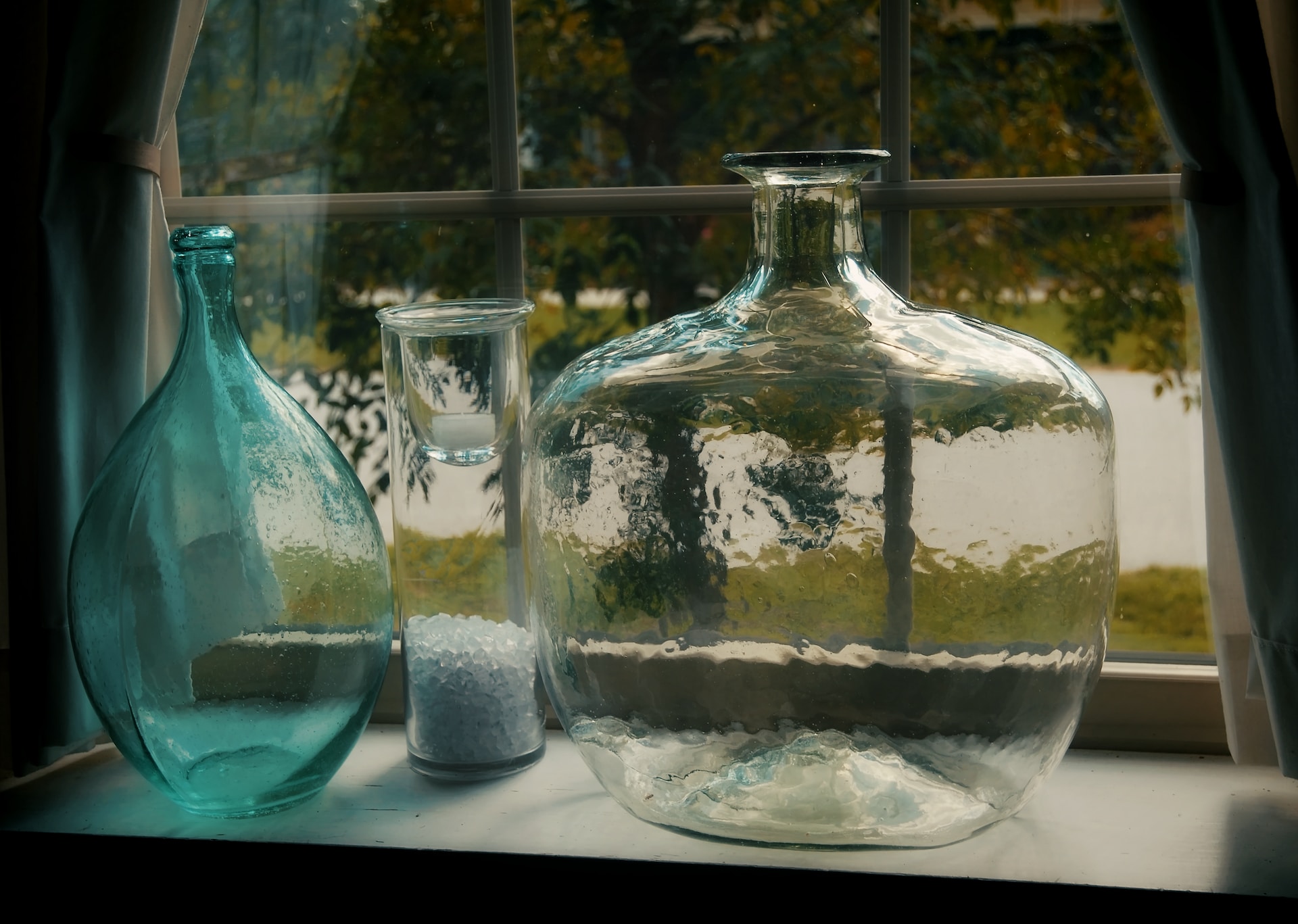  large glass vases on a window sill