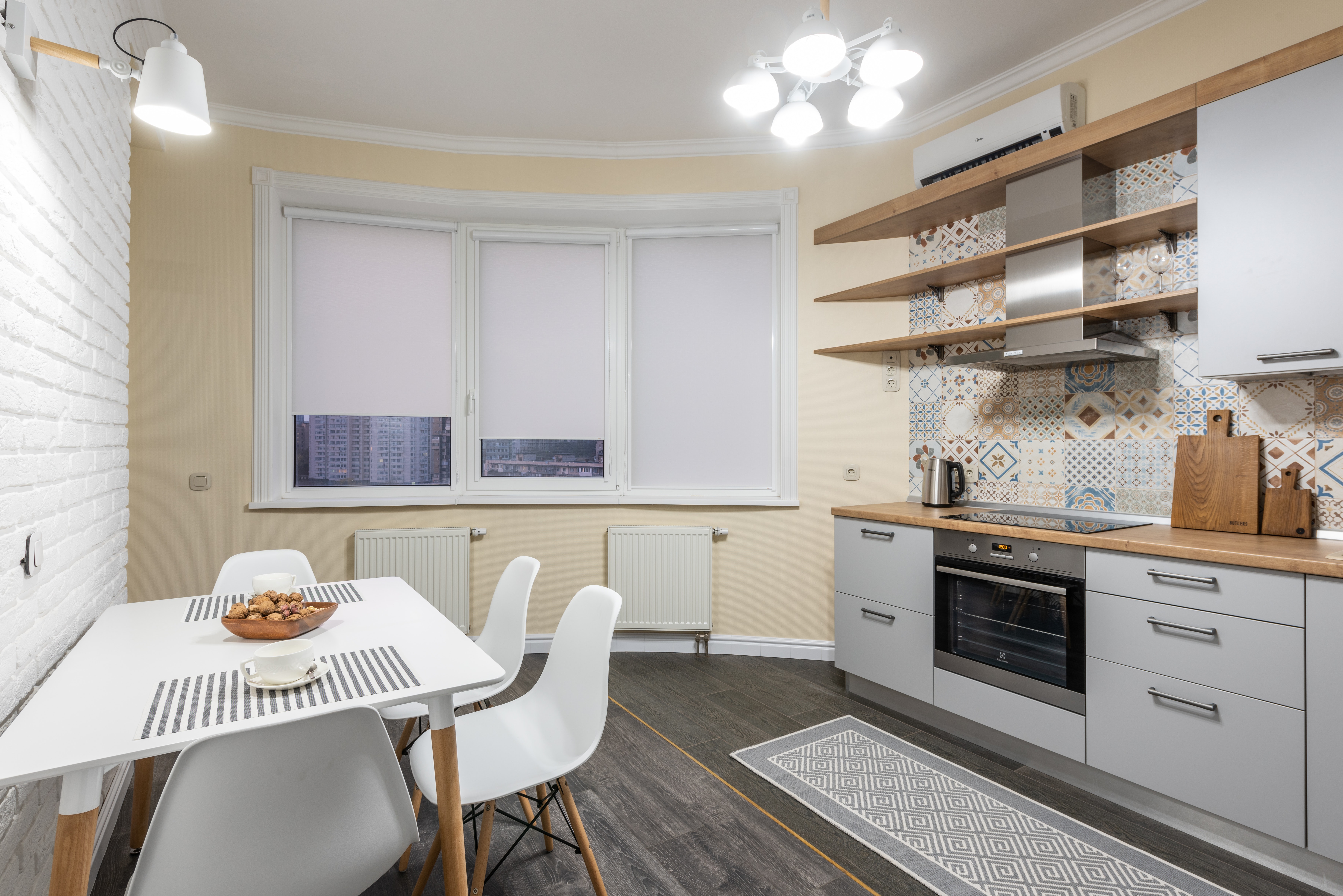 Kitchen with a round yellow wall and a colorful backsplash