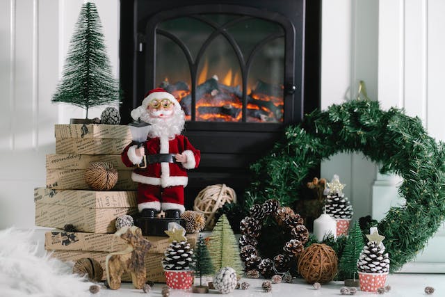  A Santa Claus toy and pinecones in front of the fireplace.