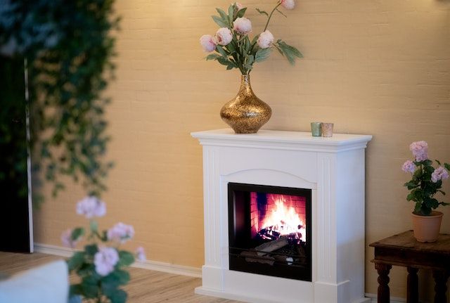 Mantel with a flower vase.