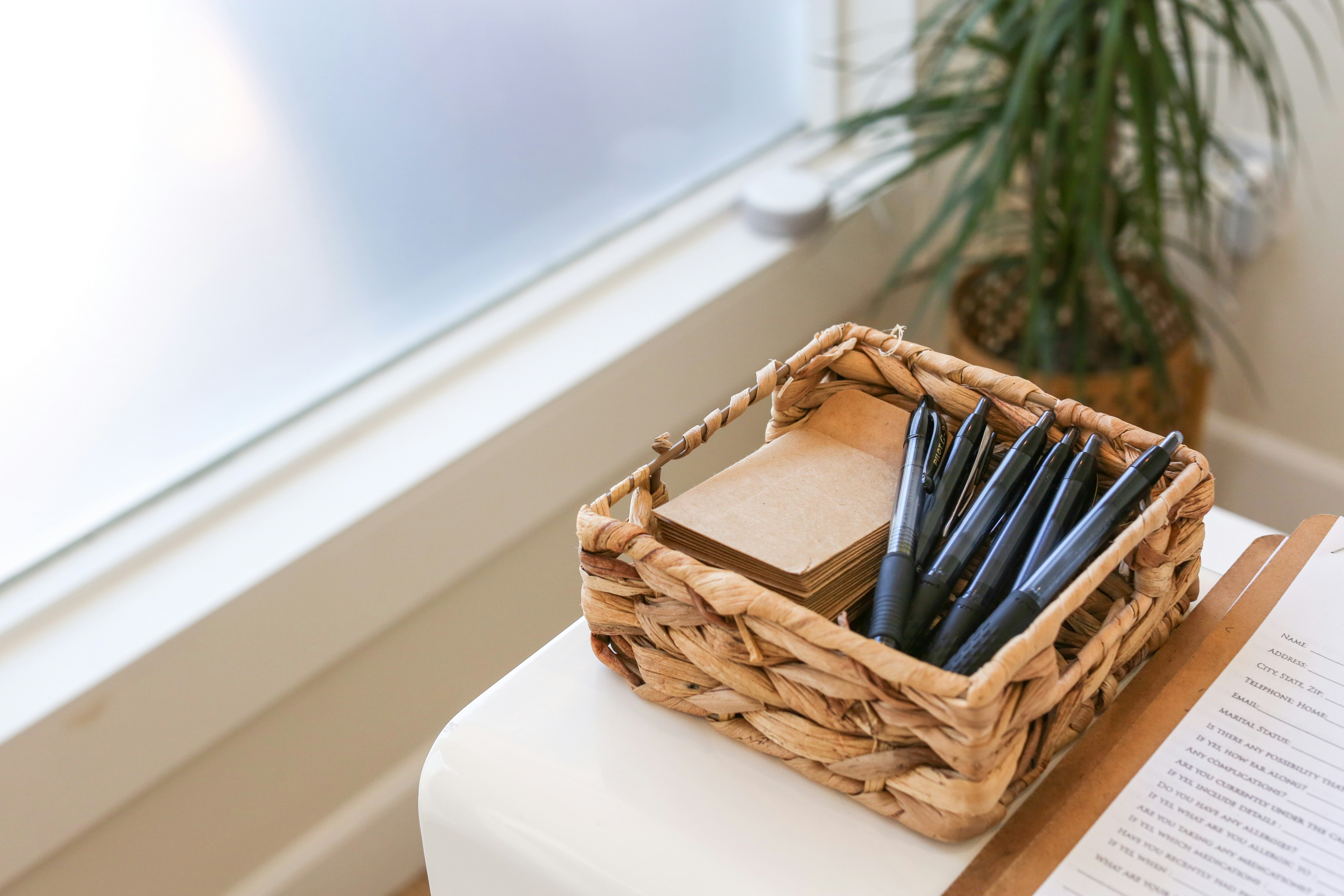 Woven basket with black pens and paper