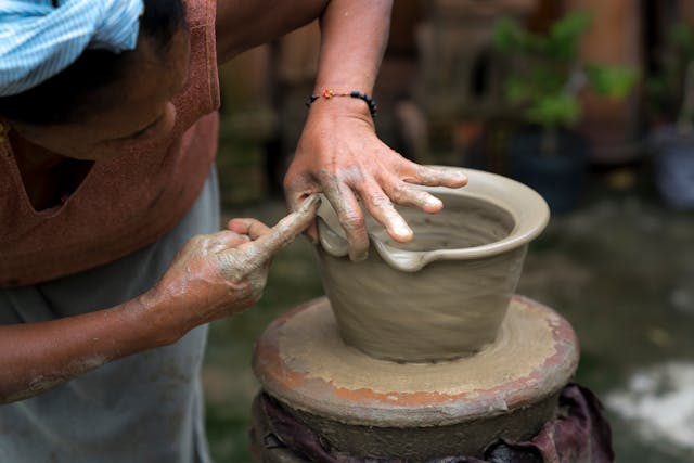 Woman molding the edges of a pot