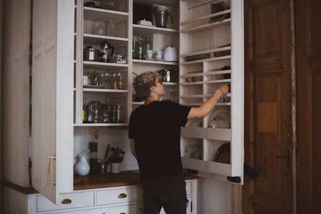 A person using a functional kitchen pantry cabinet.